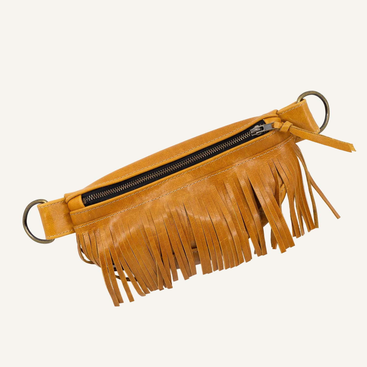 Brown leather fringe bag with gold rings on a white background
