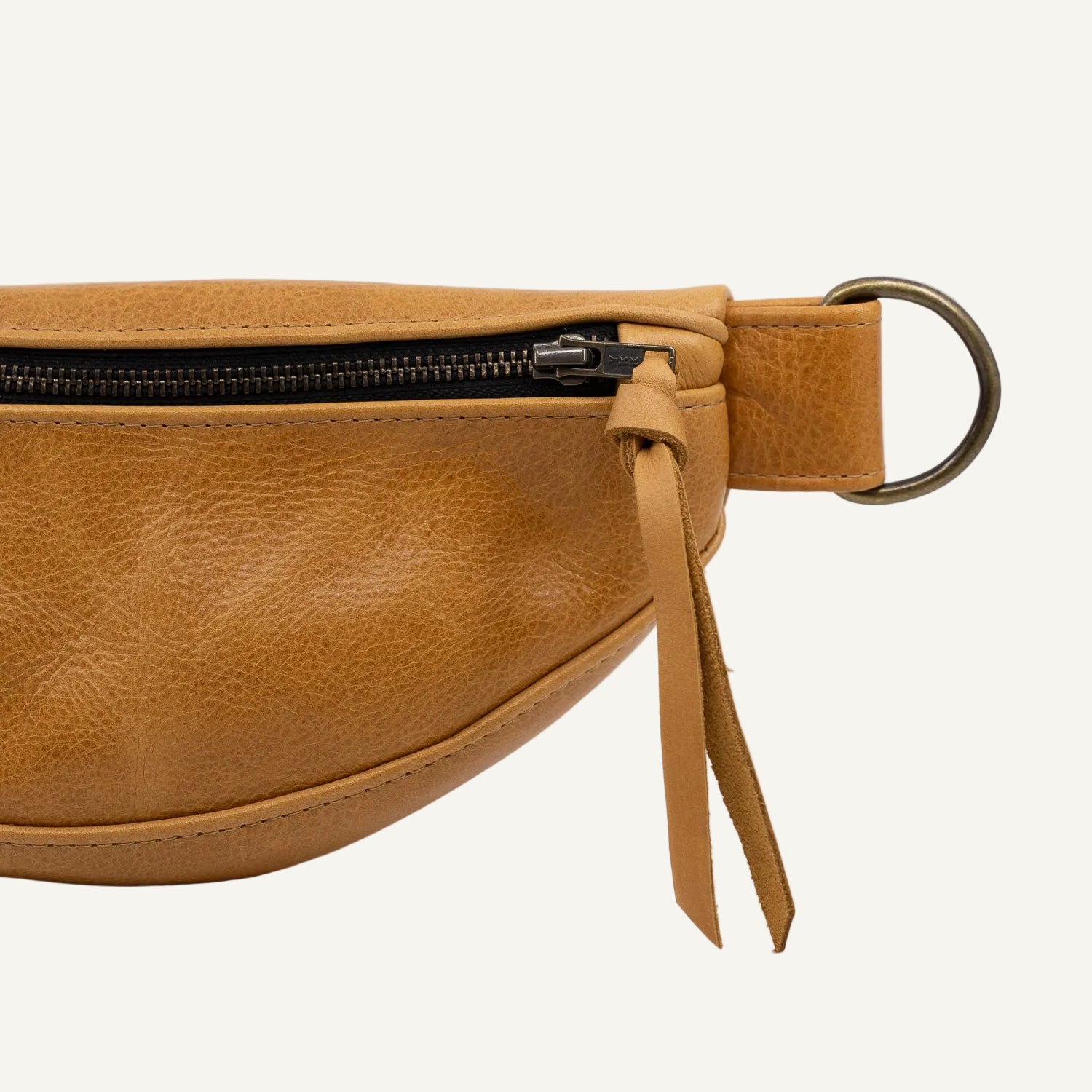 Brown leather fanny pack with black zipper on a white background