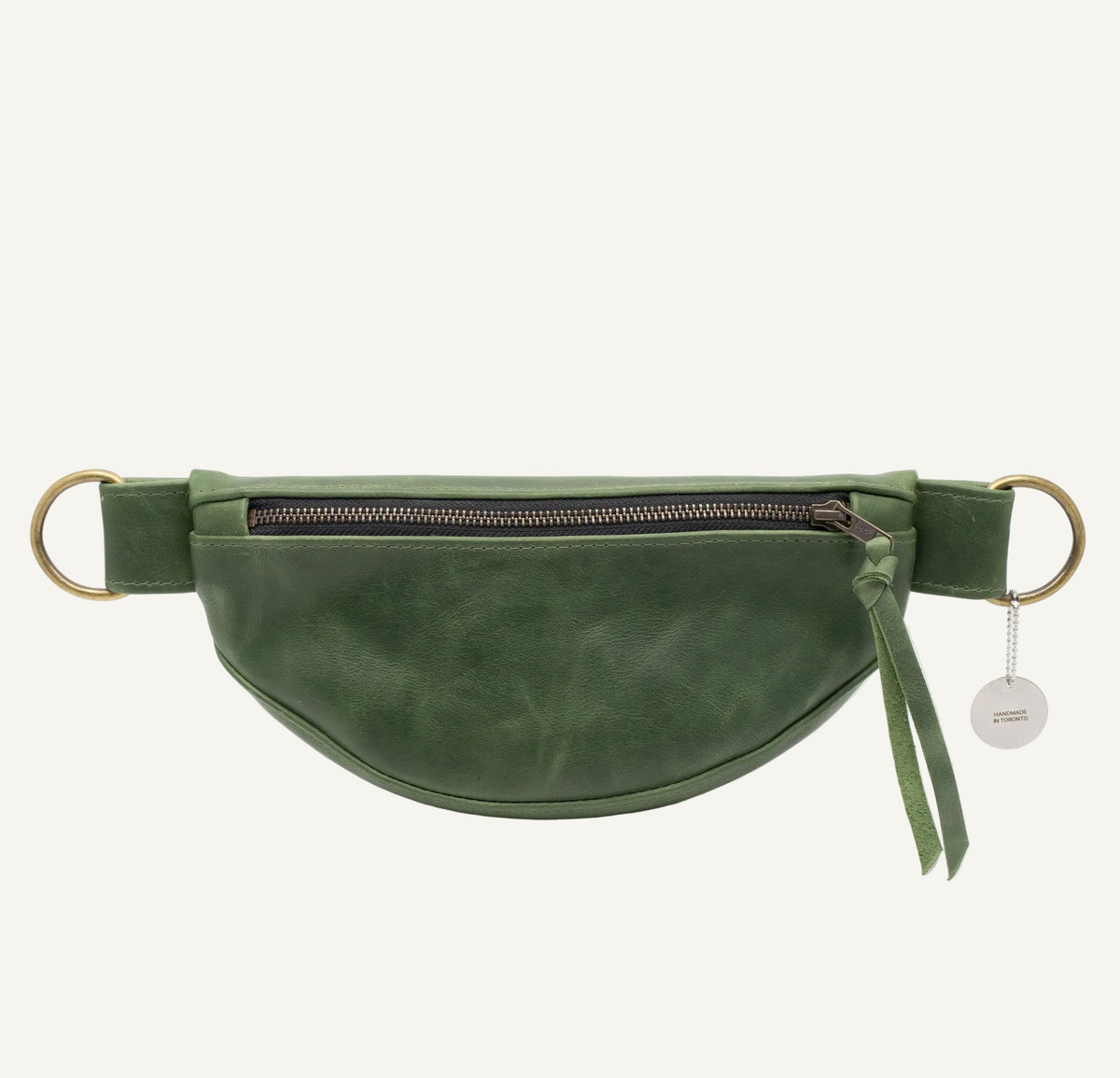 Green leather waist bag with a gold zipper on a white background
