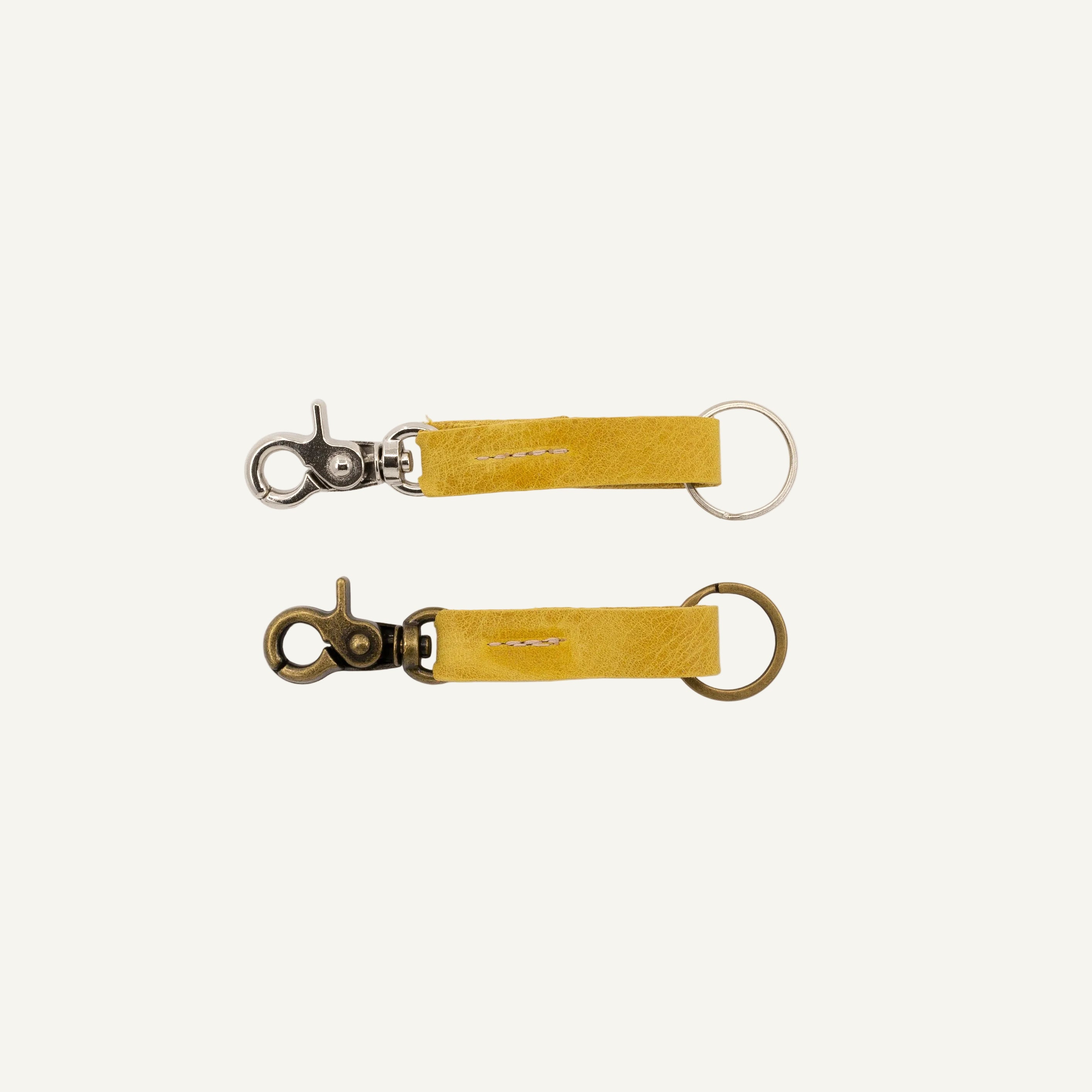 Two yellow keychains with metal clasps on a white background