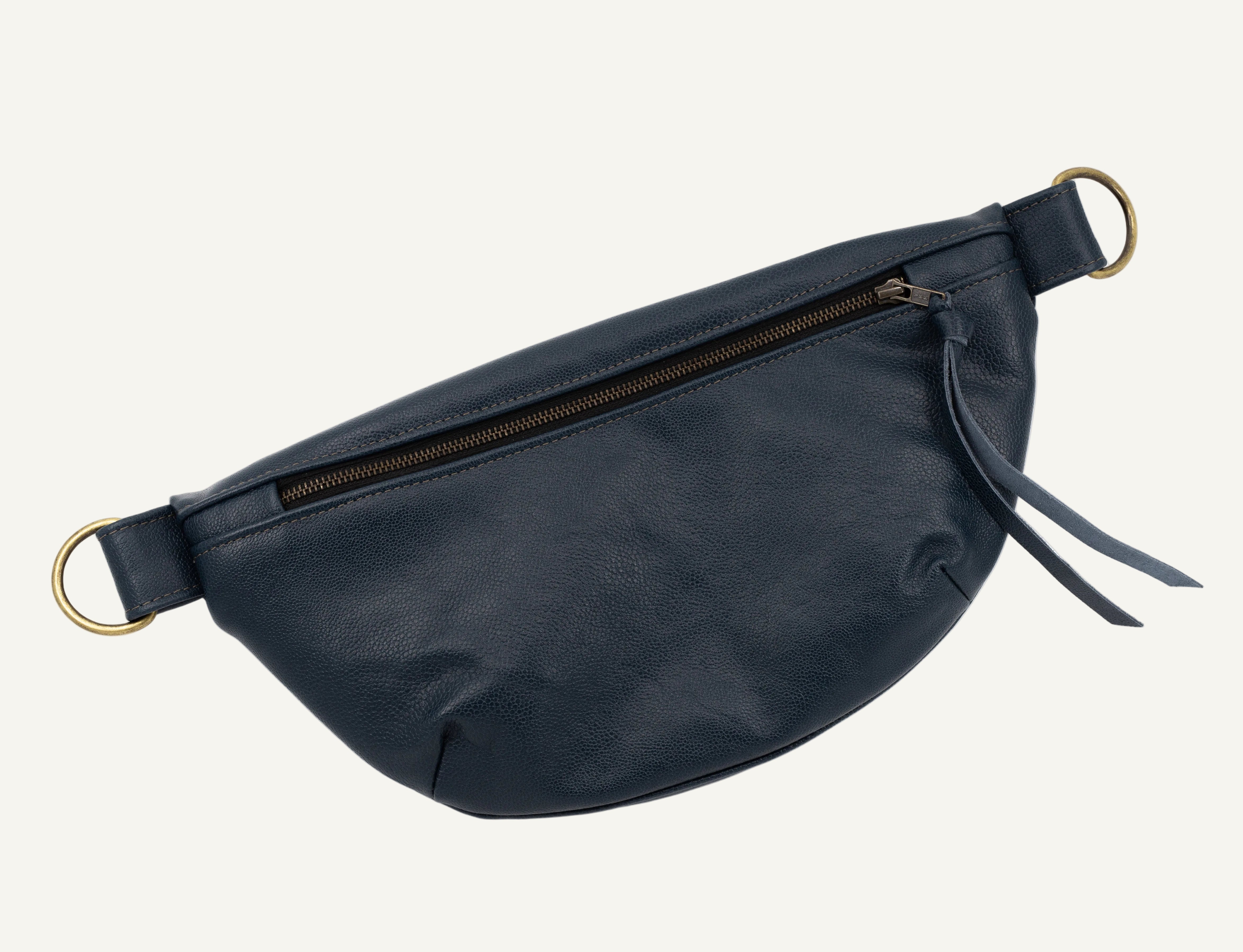 A dark navy blue leather fanny pack with a front zipper pocket, featuring gold-tone metal hardware rings and a matching leather tassel zipper pull, shown on a plain white background.
