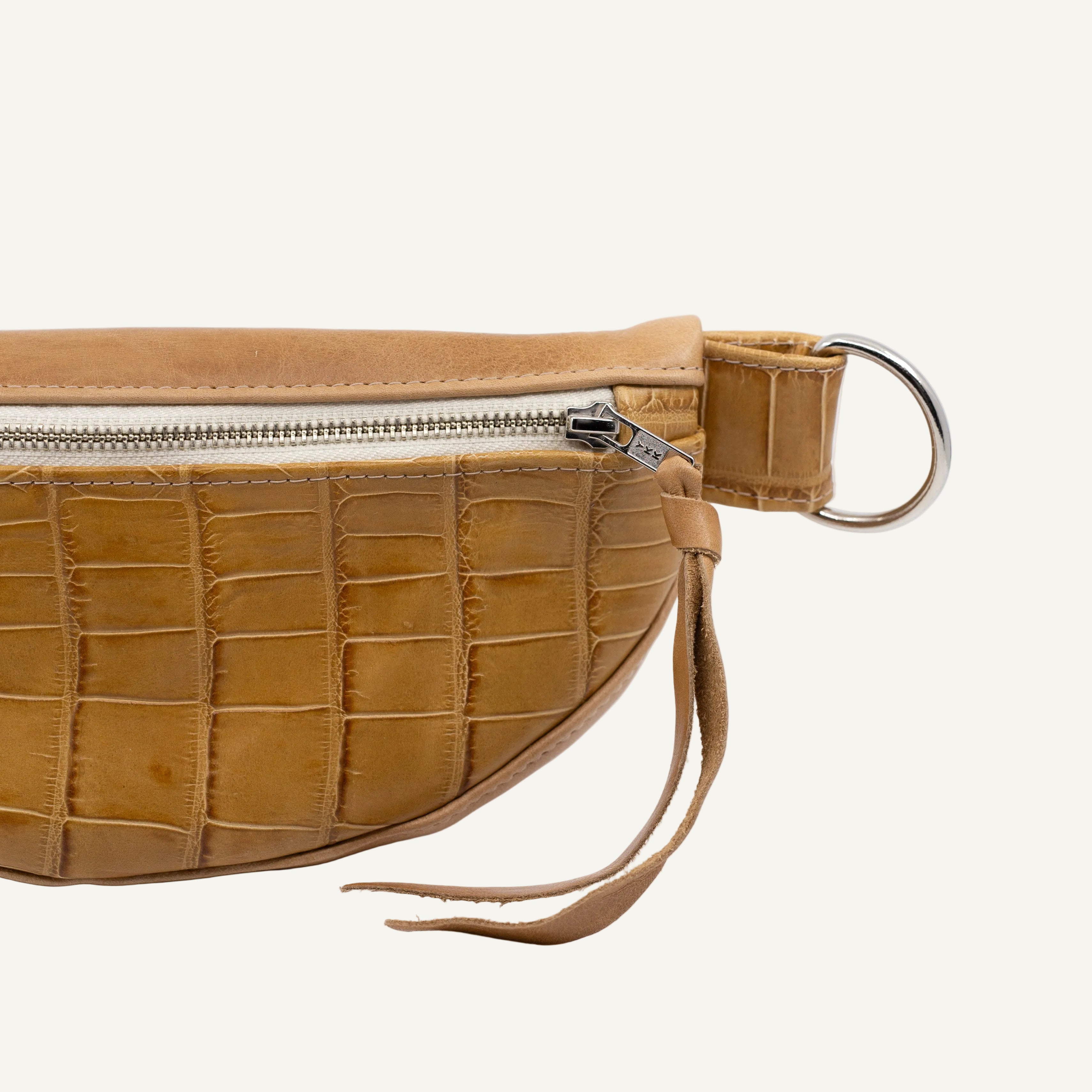 natural leather waist bag with crocodile texture on a white background
