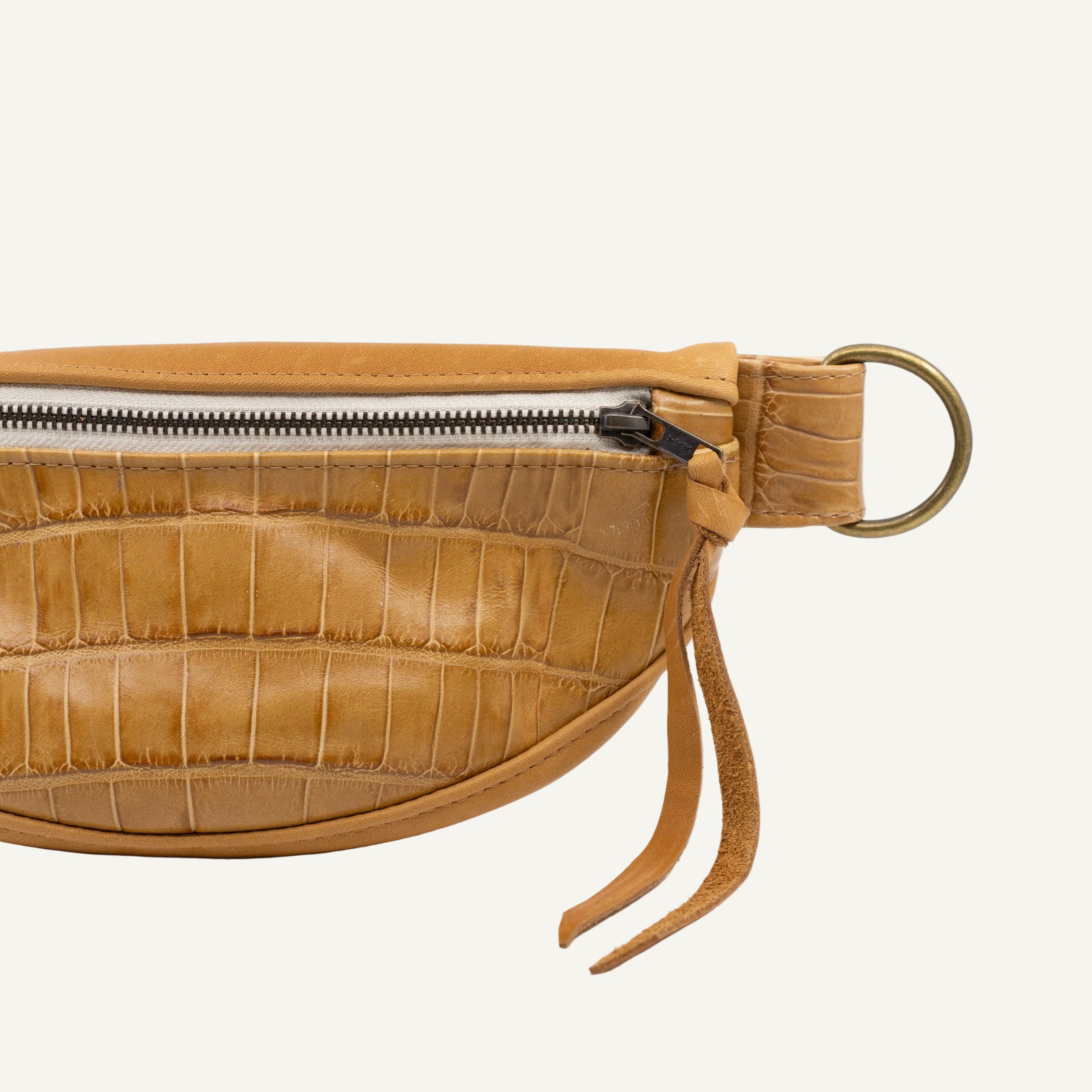beige leather waist bag with crocodile texture on a white background