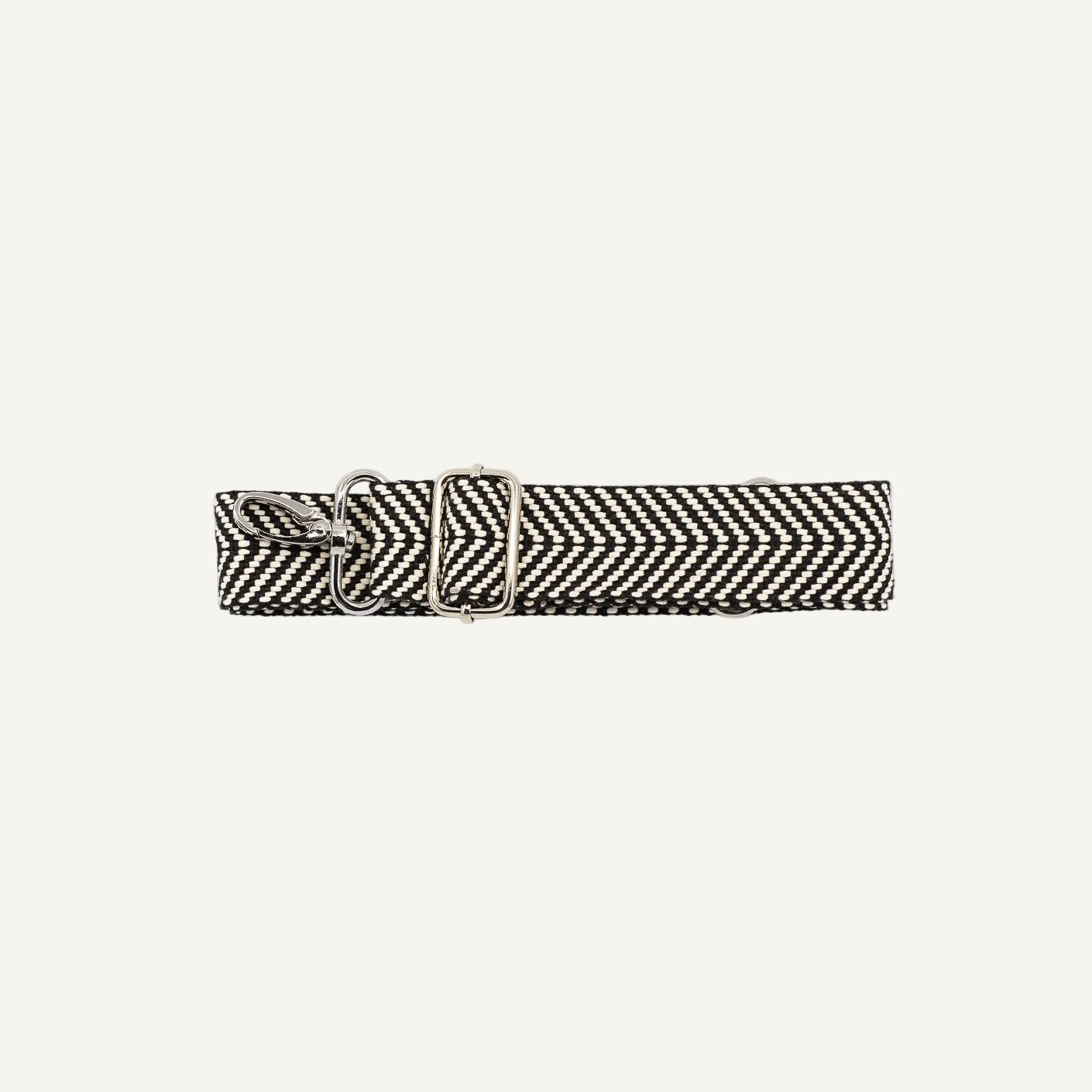 Black and white woven belt with a metal clip on a light gray background