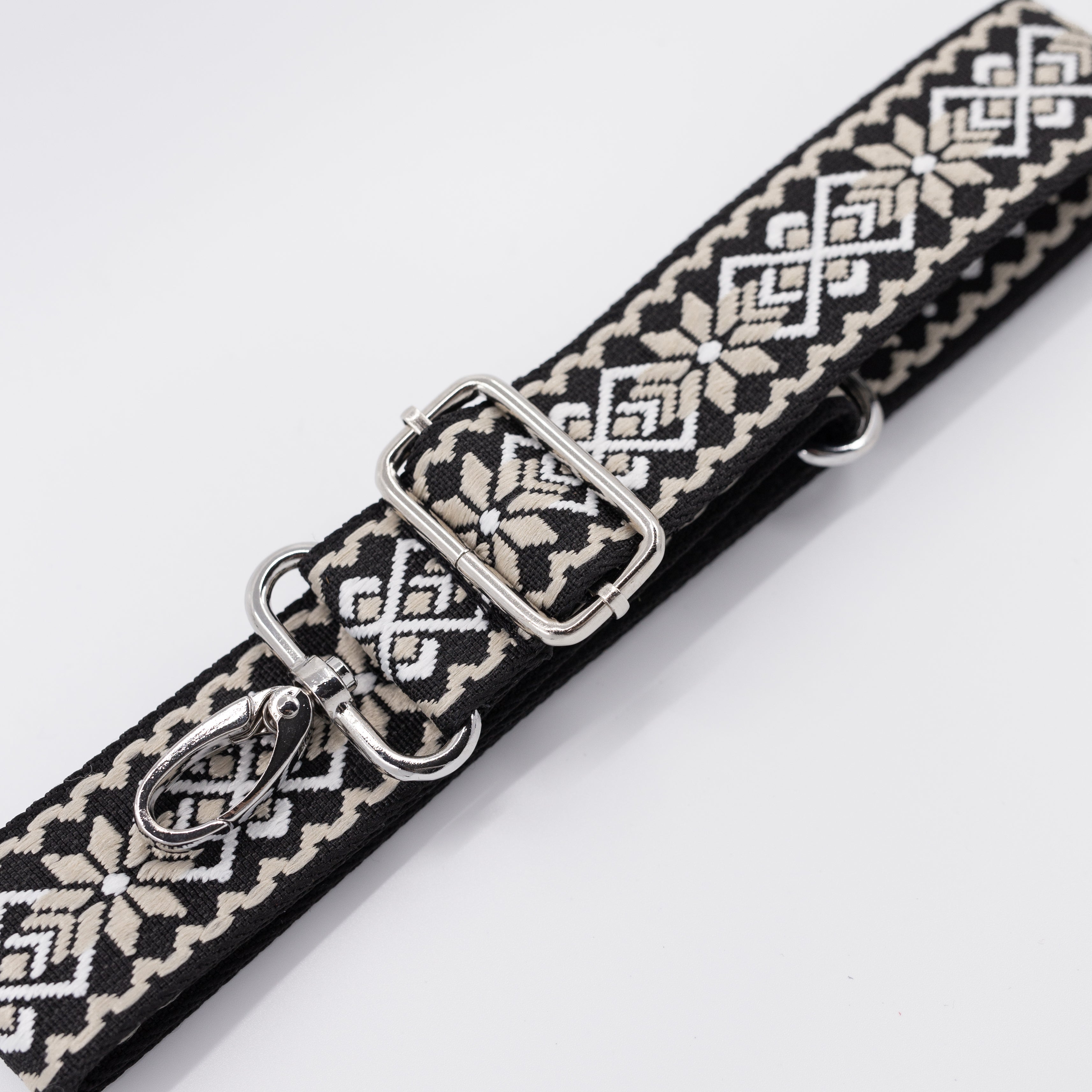 Patterned belt with metal clip on a white background