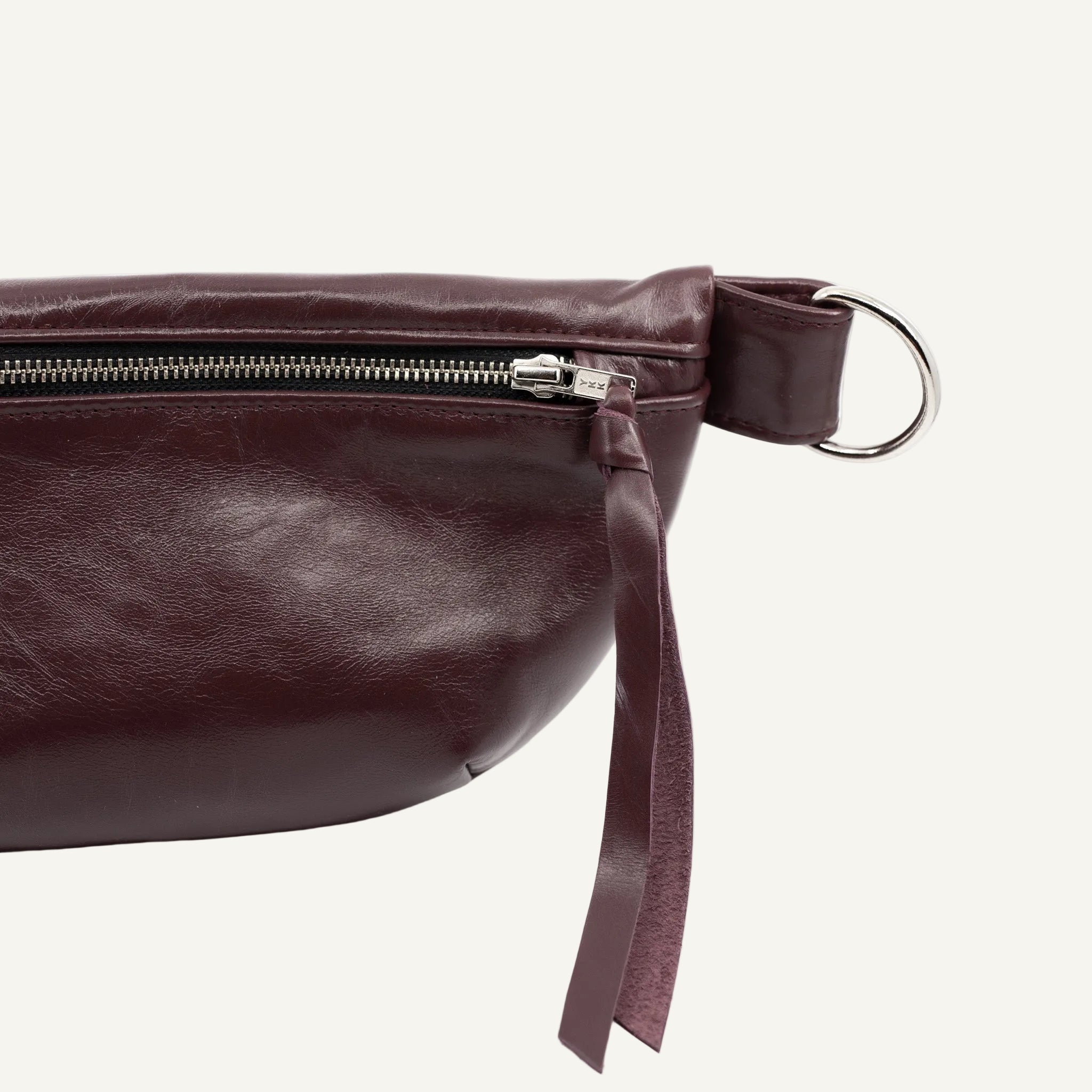 Merlot Red leather bag with a strap on a white background