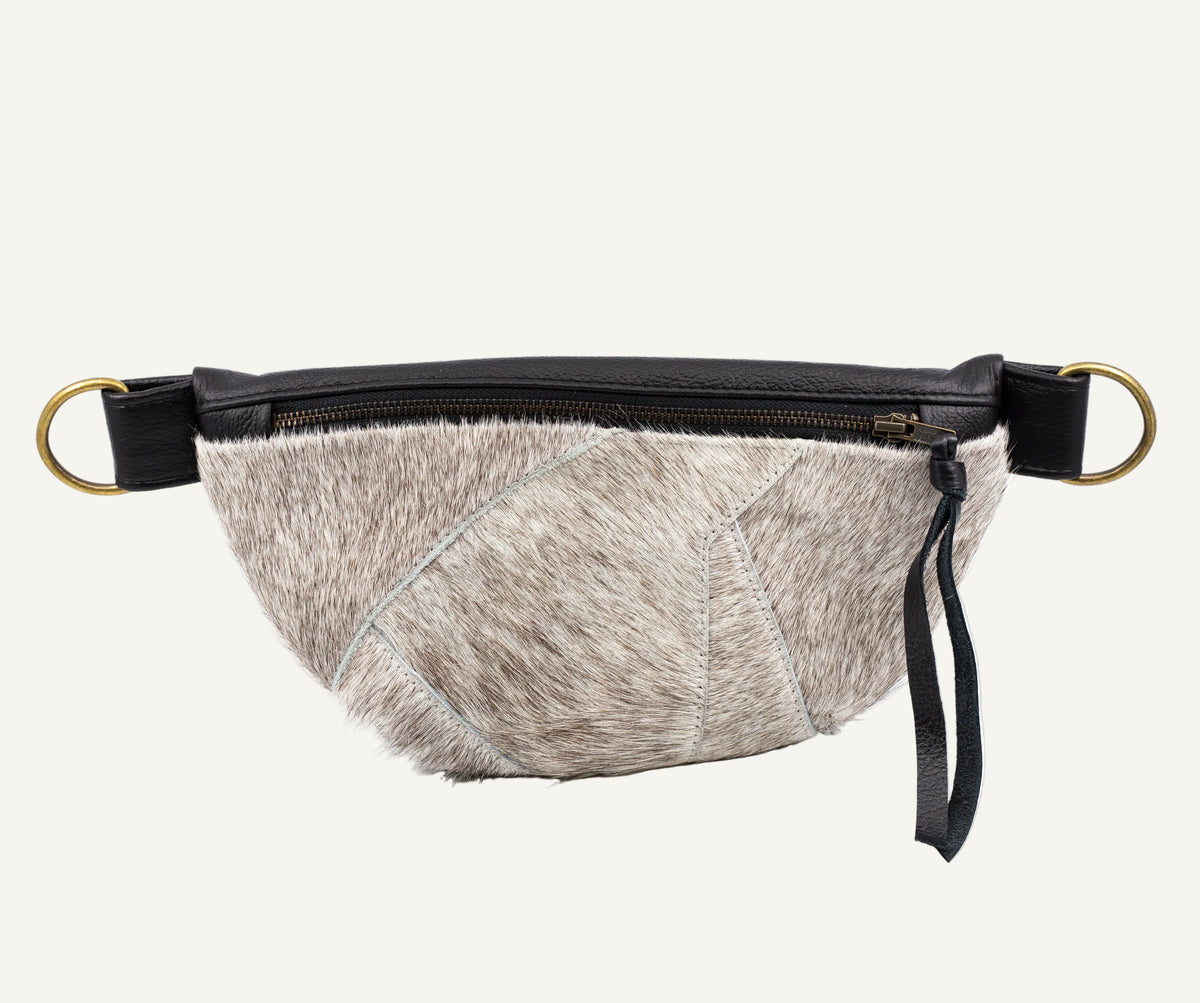 A small furred waist bag with a black leather zipper and strap, featuring gold-tone hardware rings on a white background.