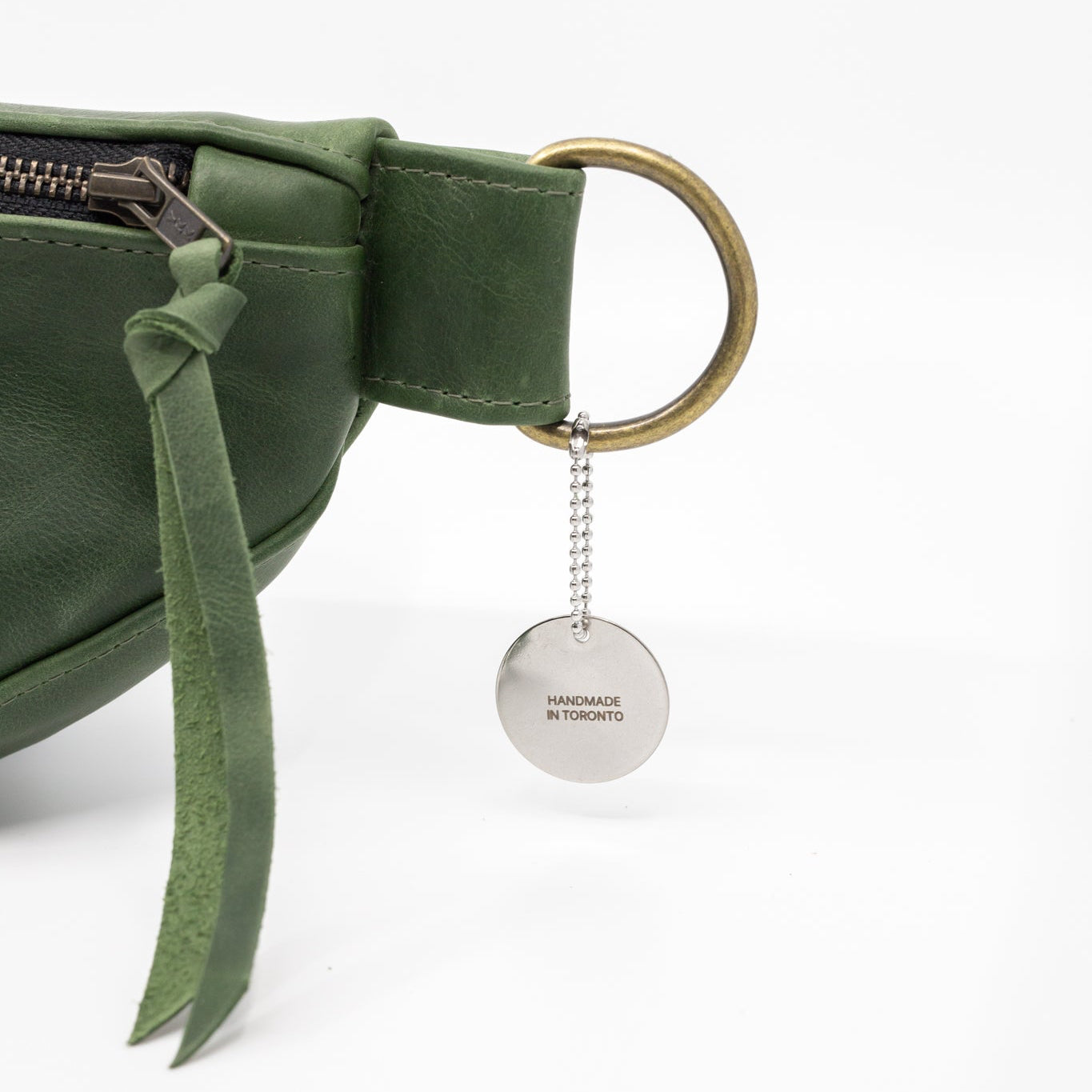 Green belt bag with a keychain on a white background