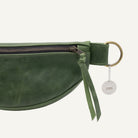 Green leather waist bag and gold zipper on a white background