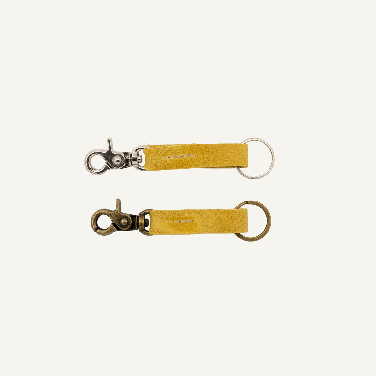 Two yellow keychains with metal clasps on a white background