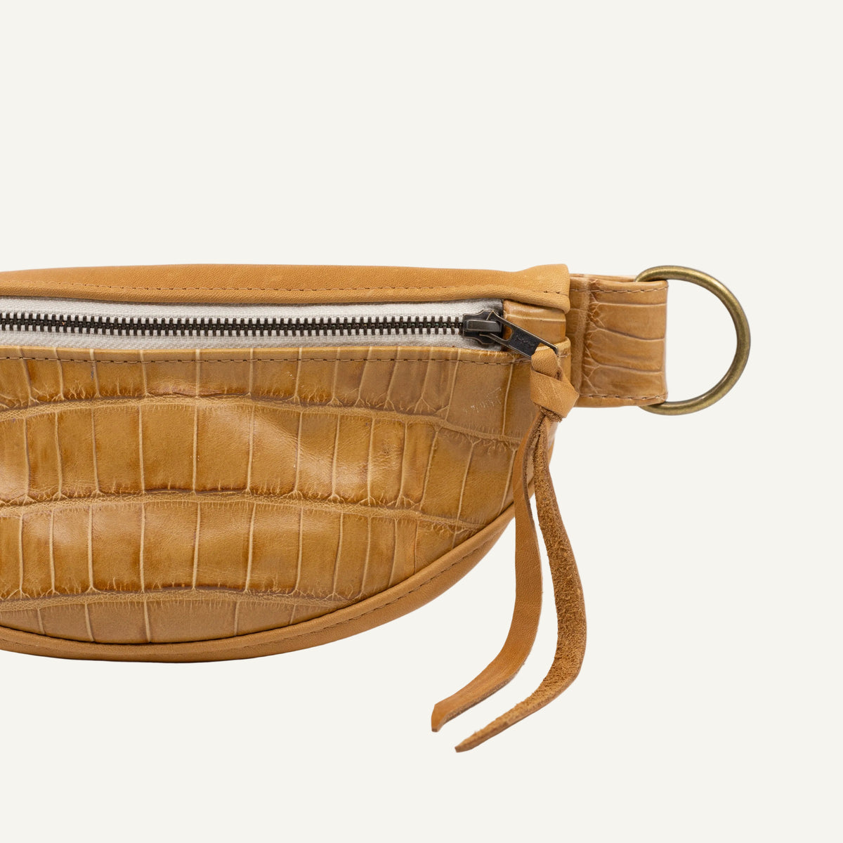 beige leather waist bag with crocodile texture on a white background