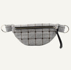 A gray and black plaid fabric fanny pack with a top zipper, and black leather tassel, shown against a plain white background.