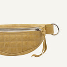 A small yellow quilted fanny pack with a metal zipper, featuring a textured pattern.