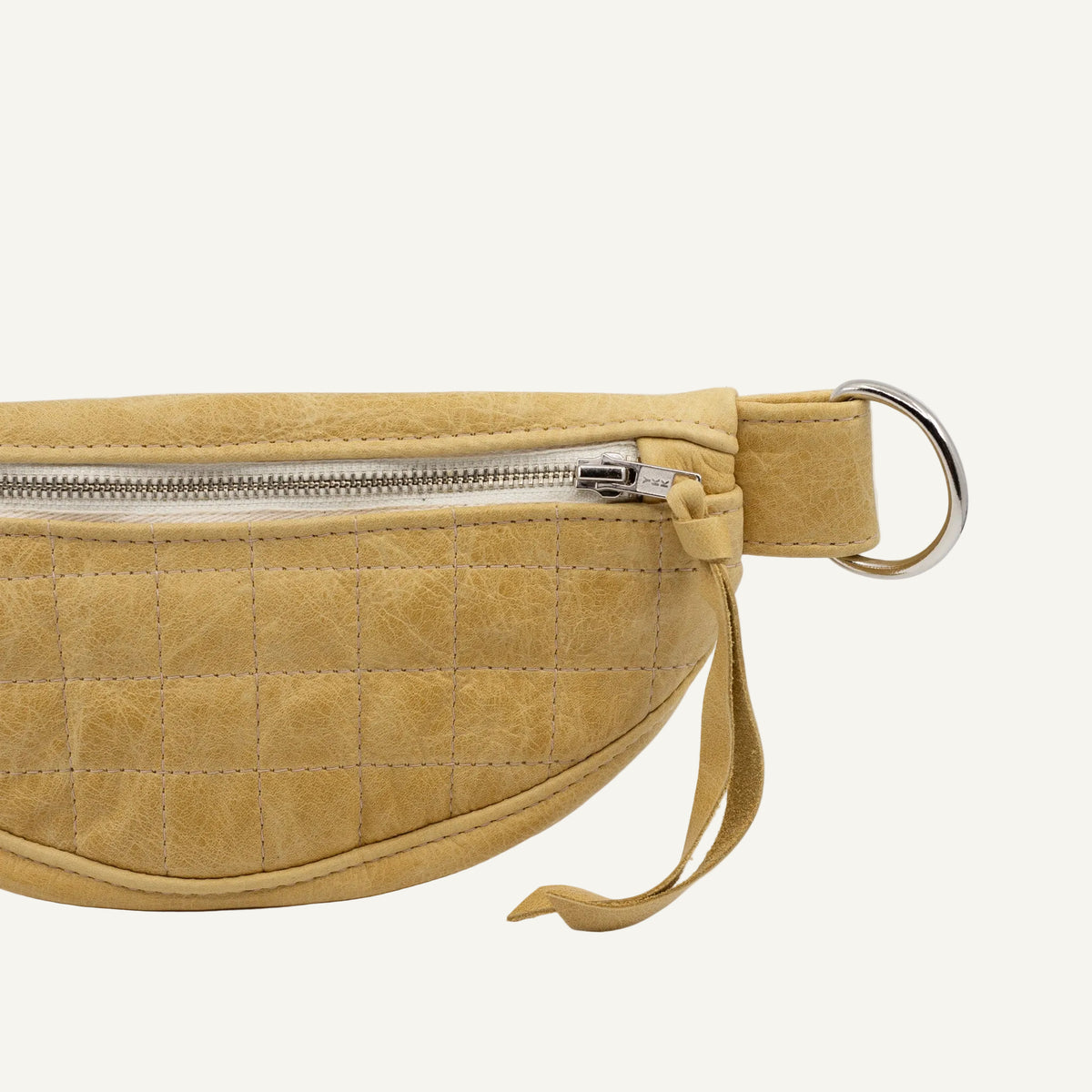 A small yellow quilted fanny pack with a metal zipper, featuring a textured pattern.