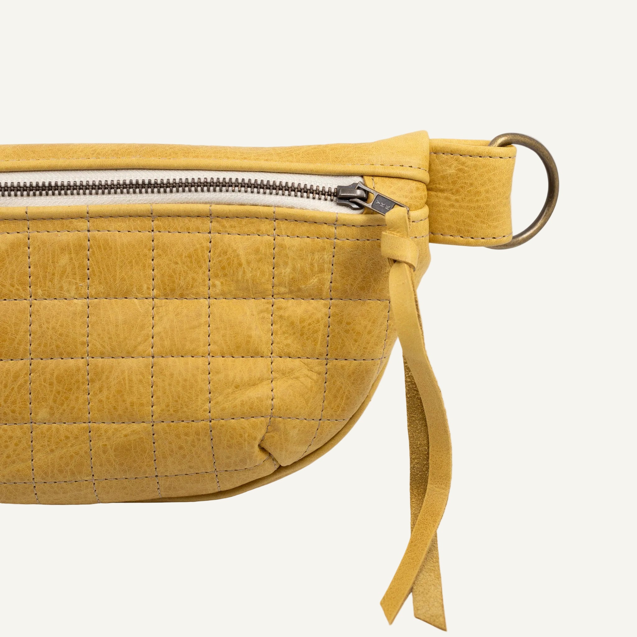 Yellow quilted waist bag on a white background