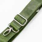 Green leather strap with silver clips on a white background