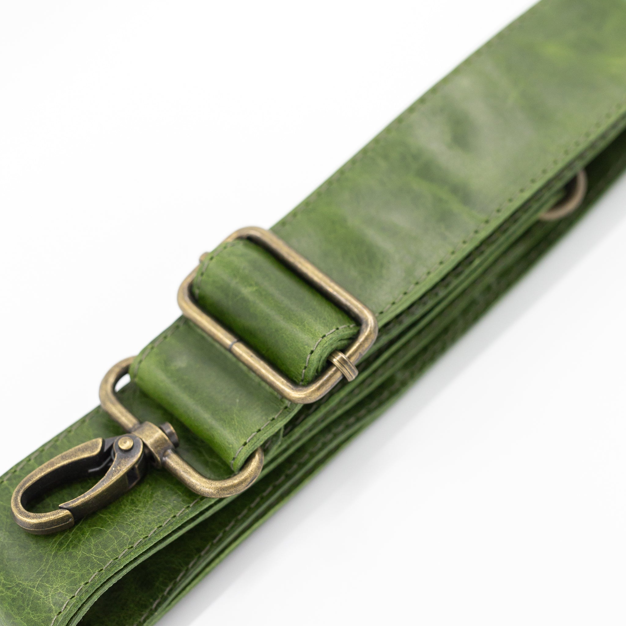 Green leather strap with brass clips on a white background