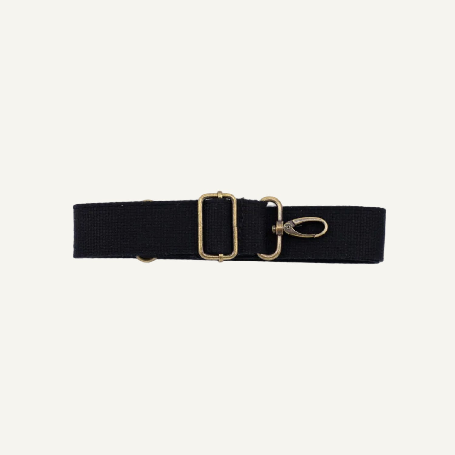 Black strap with brass clips on a white background