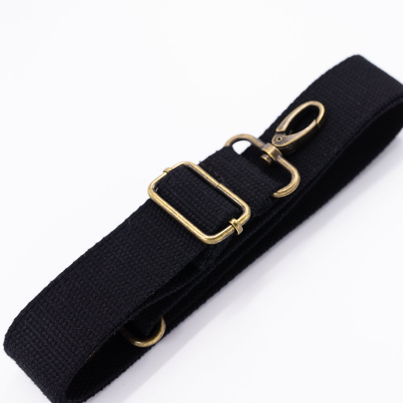 A black cotton detachable strap with a gold-colored clip, displayed on a white background