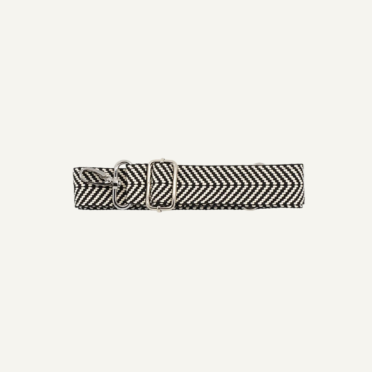 Black and white woven belt with a metal clip on a light gray background