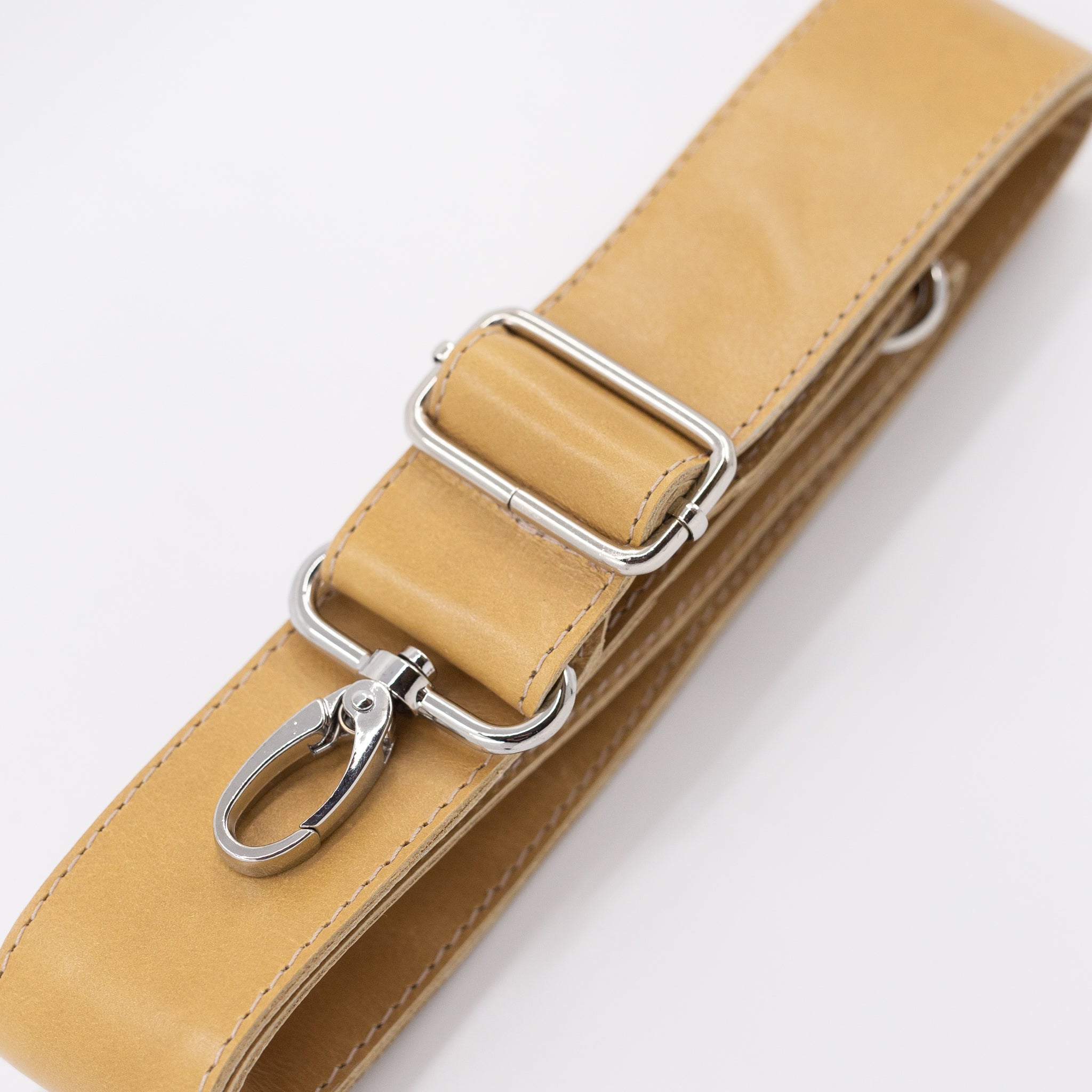 Tan leather strap with silver clips on a white background