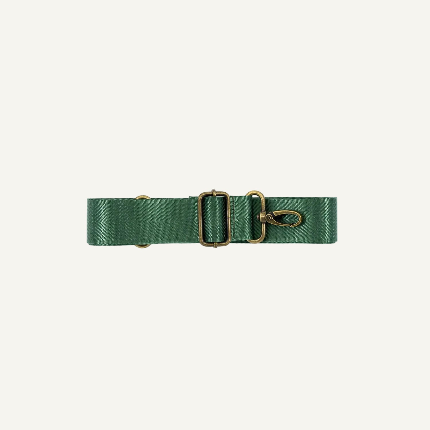 Green seatbelt strap with brass hardware on a white background