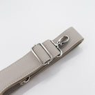 Gray leather belt with silver buckle on a light gray background