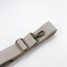 Light gray leather belt with a brass buckle on a white background