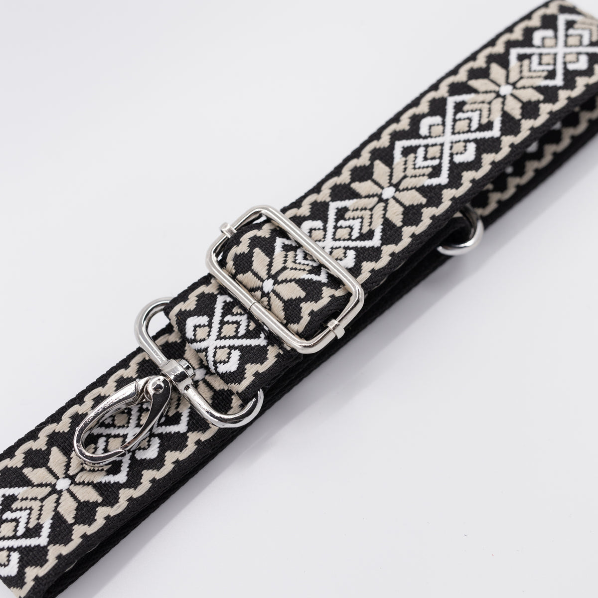 Patterned belt with metal clip on a white background