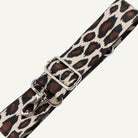 Leopard print strap with metal buckle on a light gray background