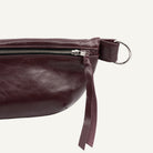 Merlot Red leather bag with a strap on a white background