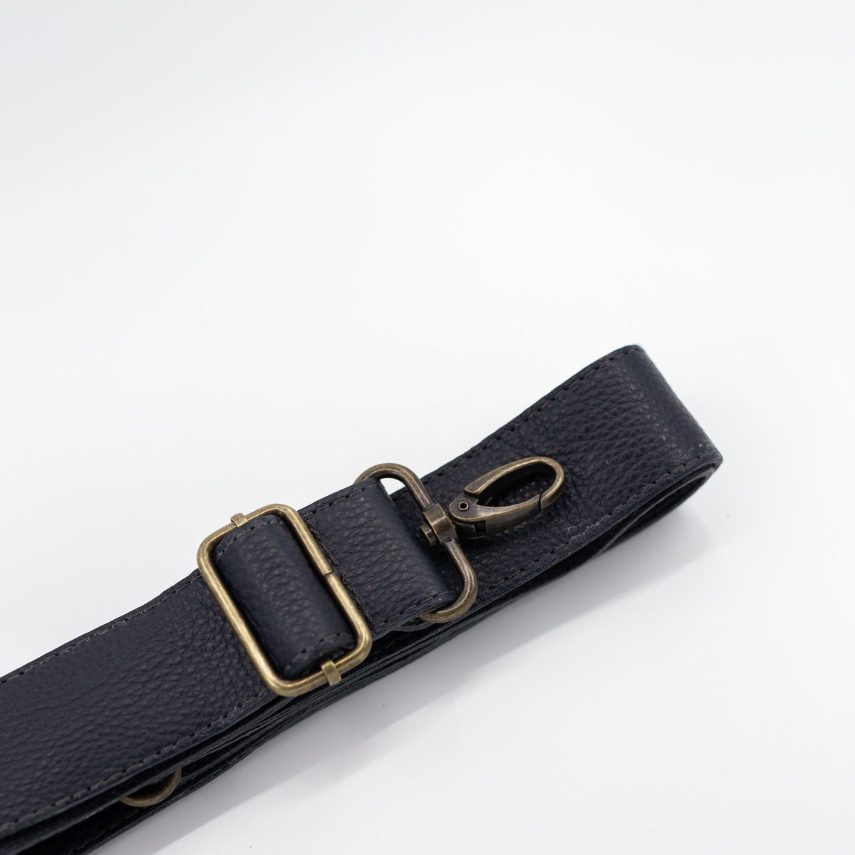 Navy leather strap with brass clips on a white background