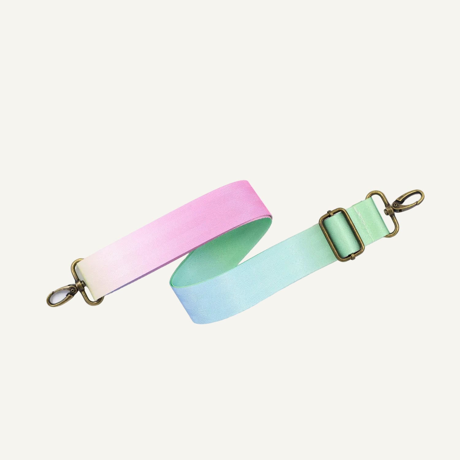 Pastel pink and green strap with gold hardware on a white background