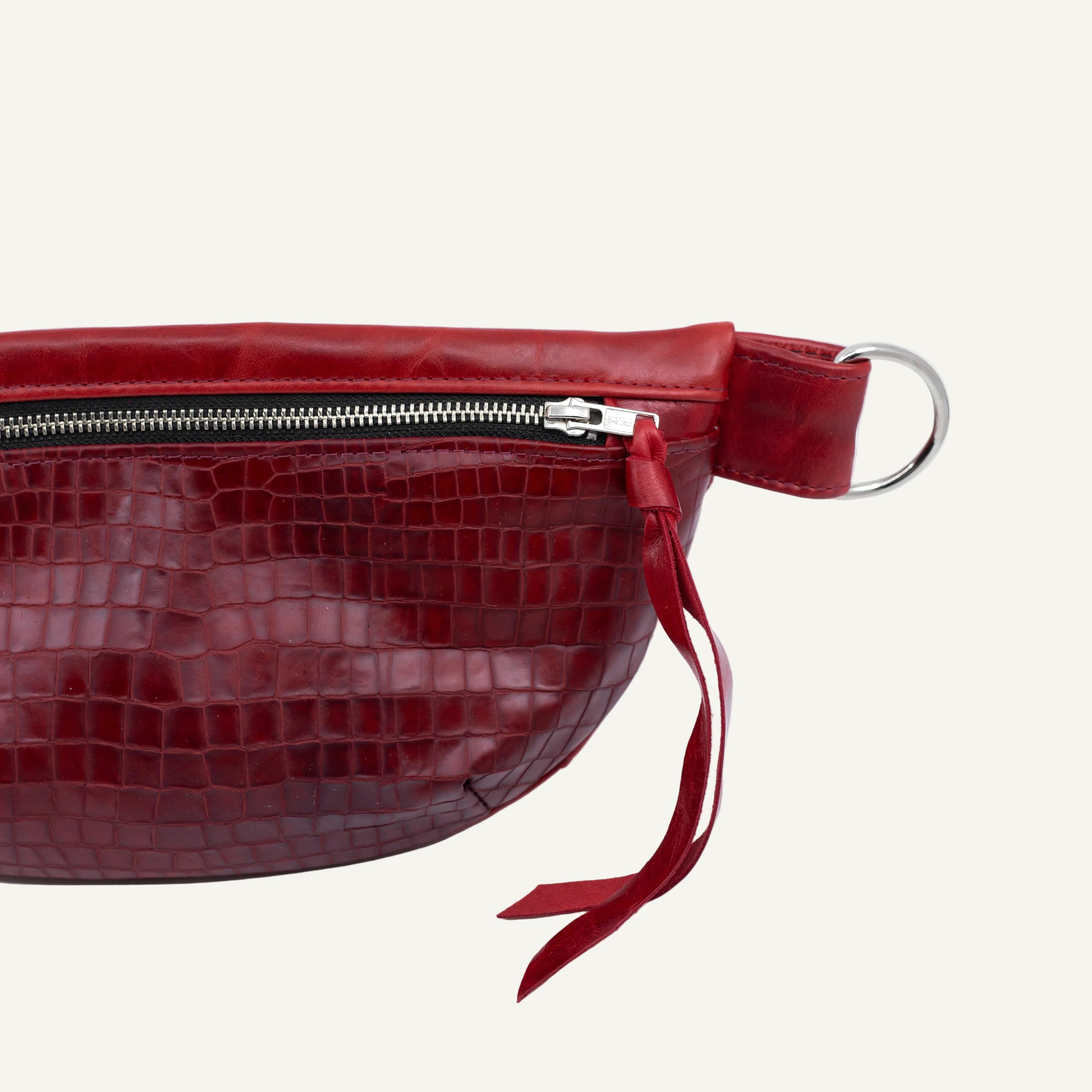 Red textured bag with a strap on a white background