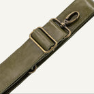 Green leather strap with brass clips on a white background