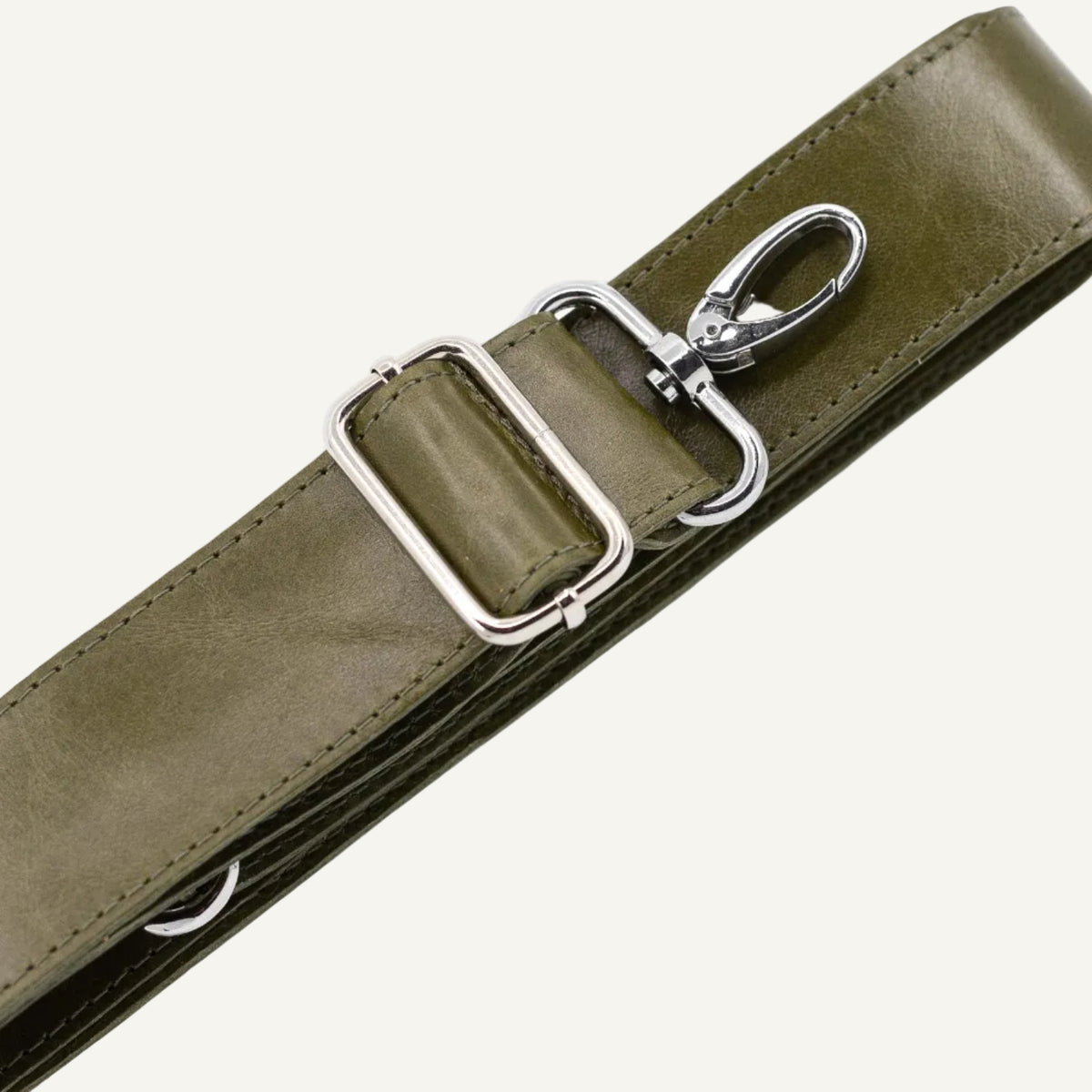 Green leather strap with silver clips on a white background