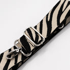 Zebra print strap with silver hardware on a white background
