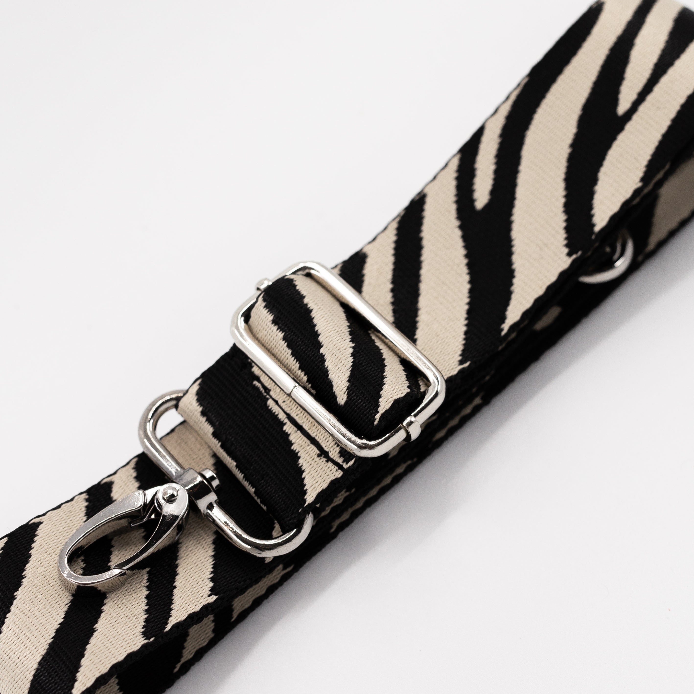 Zebra print strap with silver hardware on a white background