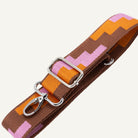 Colorful fabric strap with metal clips on a white background