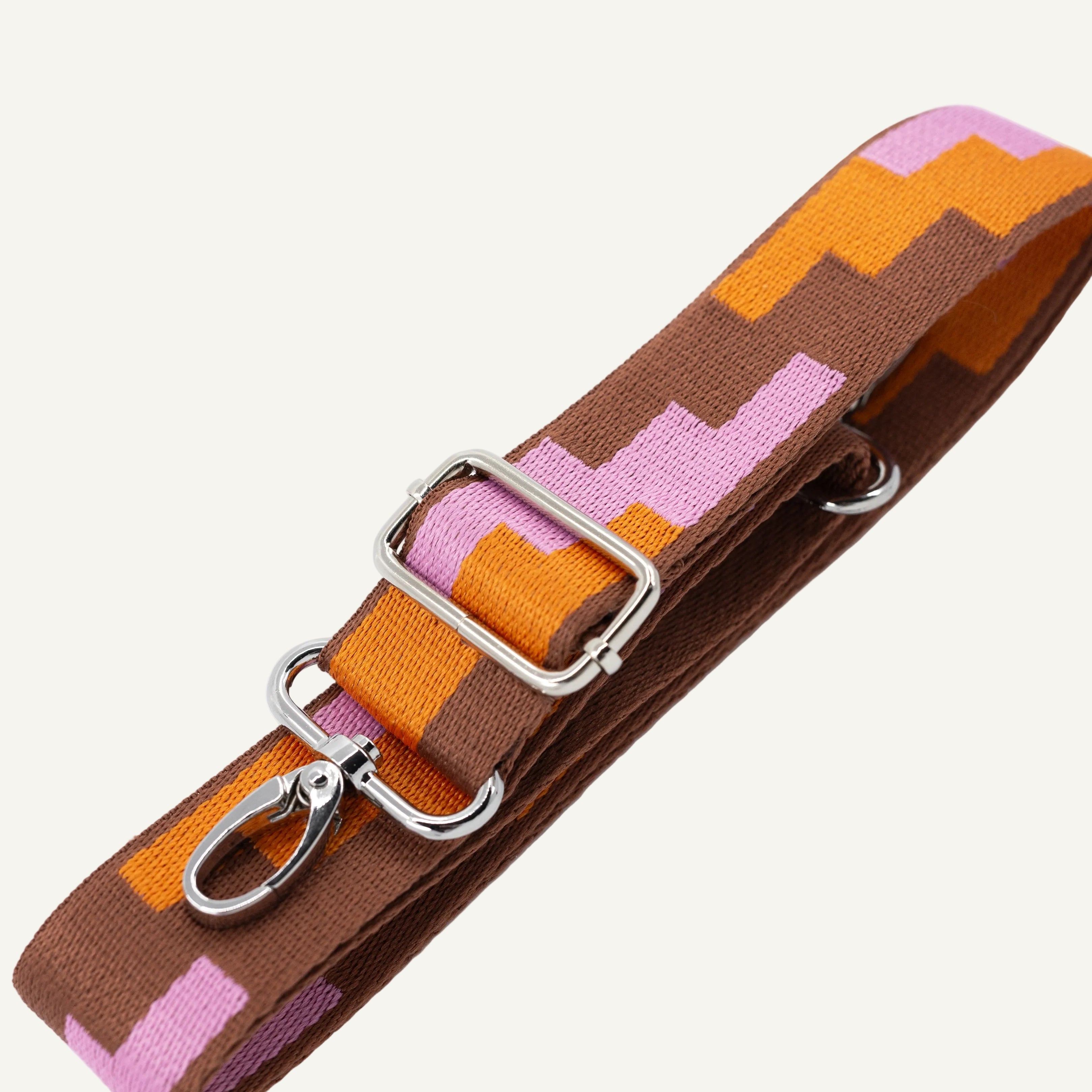 Colorful fabric strap with metal clips on a white background