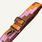Patterned strap with brass clip on a white background