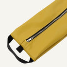 Yellow storage bag with a black strap and zipper on a white background