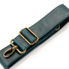 A dark teal leather strap with antique brass hardware, including a swivel clasp, shown on a clean white background.