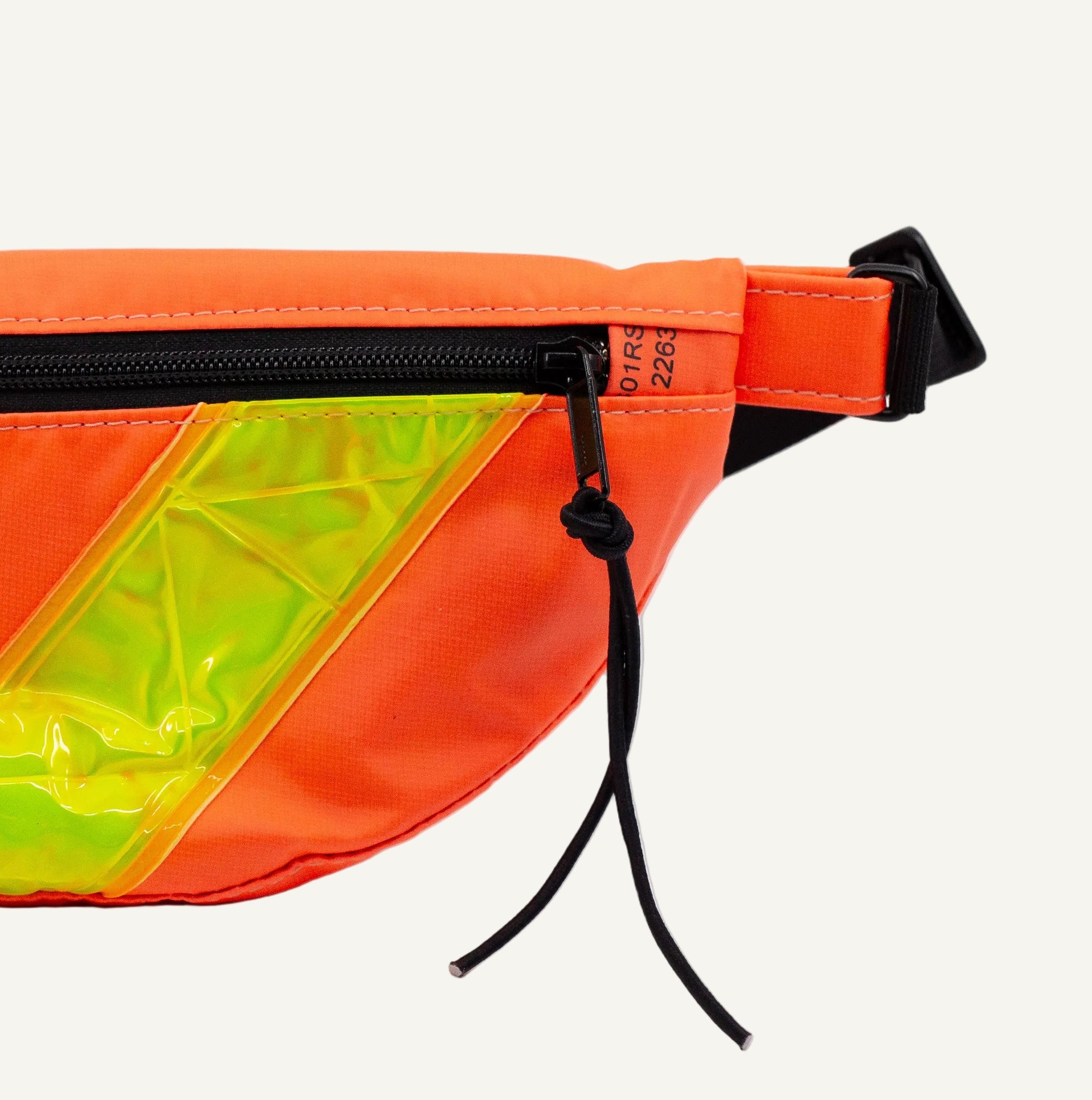Orange fanny pack with a green reflective strip on a white background
