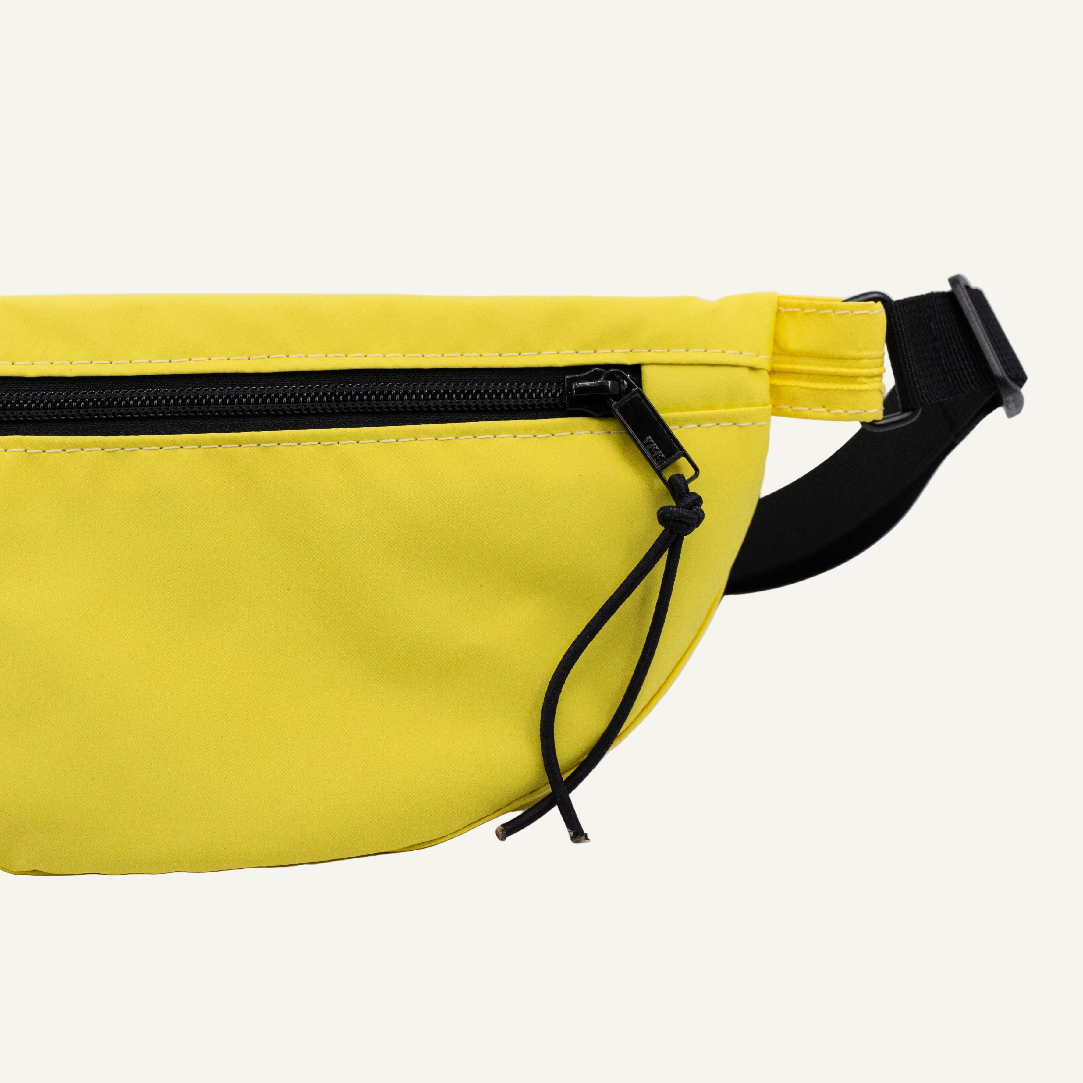Yellow waist bag with a black strap on a white background