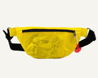 A bright yellow fanny pack with black straps and zipper trim, featuring black line-art illustrations and text including 'AIR CRUISERS'. A small red plastic tag hangs from the side zipper.