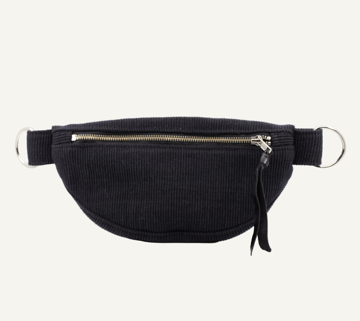 A black ribbed corduroy waist bag with a top zipper, silver-tone metal D-rings, and a black leather tassel pull, shown against a plain white background.