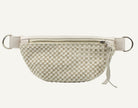 A cream-colored leather half-moon fanny pack with a zippered top, adjustable strap, and silver-tone metal rings, shown against a plain white background.