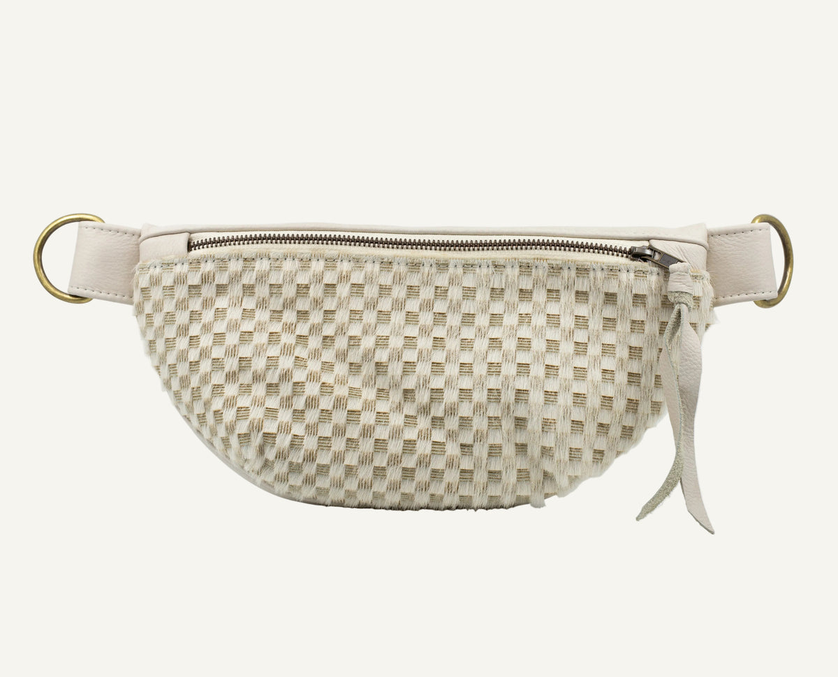 A beige leather fanny pack with a zippered front, adjustable strap, and gold-tone hardware, shown against a plain white background.